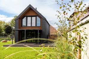 a black house with a large window on a yard at Bike ApartHouse 44 in Radomierzyce