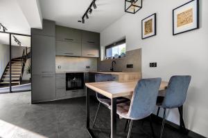 a kitchen with a wooden table and two chairs at Bike ApartHouse 44 in Radomierzyce