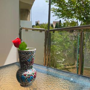 a vase with a rose in it sitting on a table at SEAL of Deer - Castle View - 5 minute walk to the Beach in Rhodes Town