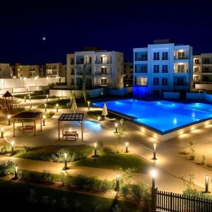 una grande piscina di notte con luci di Al Alamein North Coast A Luxury two Rooms Chalet at Amwaj a El Alamein