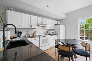 ウィリアムズタウンにあるApartment near Ark for 6 Guests - with Free Parkingの白いキャビネットとテーブルと椅子のあるキッチン