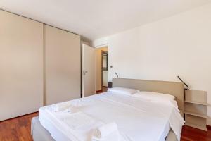 a bedroom with a large bed with white sheets at Ancien Bazar Apartement in Aosta +20 photos