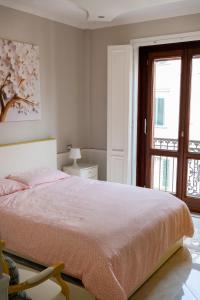 een witte slaapkamer met een bed en een raam bij Top Central Rooms in Caserta