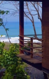 a wooden porch with a view of the beach at Casa VISTA PARAISO in Santa Teresa Beach