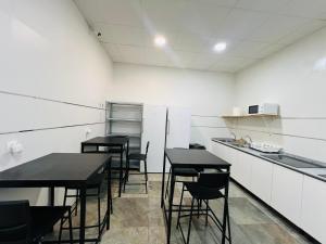 Una cocina con mesas y sillas negras en una habitación. en Cubik Rooms, en Madrid 15 fotos más