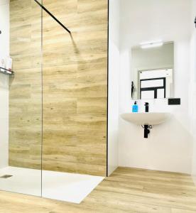 a bathroom with a glass shower with a sink at Valencia Veneta Calda in Valencia