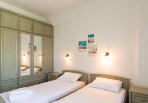 a bedroom with two beds and a cabinet at Eternal Sunset Villa #1 in Pefkohori +19 photos