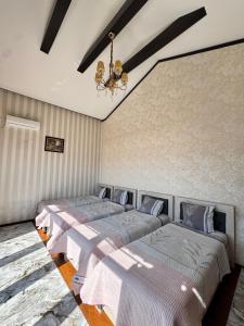 a bedroom with three beds and a chandelier at Dacha Asia in Chorwoq