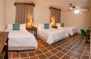 a room with two beds and a table and chairs at Hotel Casa Carmina by AHS in Antigua Guatemala