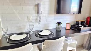 a dining table with two plates and glasses on it at Laguna 1412 - Moderno e Funcional in Sao Paulo