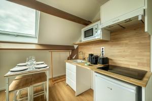 a kitchen with white cabinets and a counter top at LE MACHU PICCHU - Self Checkin Automatique - Netflix - 15 Min de Giverny in Bonnières-sur-Seine +13 photos