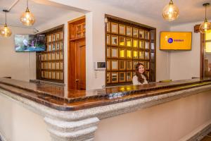 a woman sitting at a bar in a hotel at Hotel Casa Carmina by AHS in Antigua Guatemala