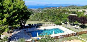 a swimming pool in a garden with a view of the ocean at Eternal Sunset Villa #2 in Pefkohori
