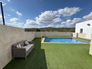 a backyard with a swimming pool and green grass at Casa Rural Cortijo Cerro Limon in Málaga