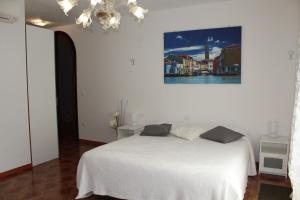 a bedroom with a white bed and white walls at B&B Airport Venice Diego in Tessera