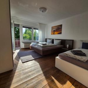 a bedroom with two beds and a large window at Happy Place Apartment XXL in Braunschweig