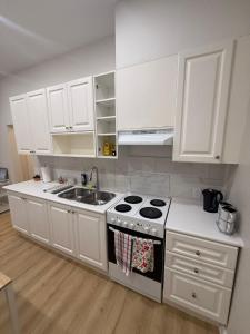 a white kitchen with a stove and a sink at Bloor & Spadina Stay- WALK TO SUBWAY, EATON CENTRE, AND NIGHT LIFE in Toronto