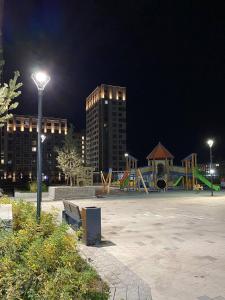 a park with a playground at night with buildings at Athletic city in Taldykolʼ