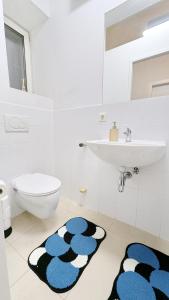 a bathroom with a sink and a toilet and a rug at Spacious Rooms - 15 Min from Airport & City Center, 5 Min from Vienna Main-Bus Station EZ1 in Vienna