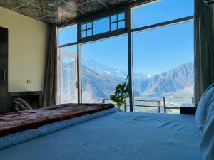 a bedroom with a bed with a view of mountains at Venus Mountain Resort, Hunza in Hunza