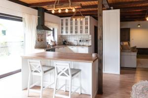 a kitchen with white cabinets and a counter with stools at Zanurzeni w Ciszy in Nowe Motule