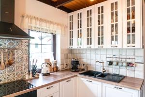 a kitchen with white cabinets and a sink at Zanurzeni w Ciszy in Nowe Motule +29 photos