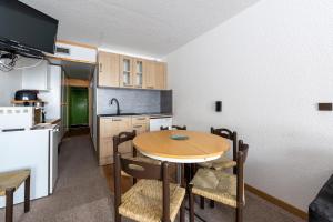 a kitchen with a table and chairs in a room at Studio 5 P Les Arcs 2000 Pieds Des in Bourg-Saint-Maurice +16 photos