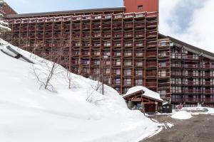 a large building with a pile of snow in front of it at Studio 5 P Les Arcs 2000 Pieds Des in Bourg-Saint-Maurice