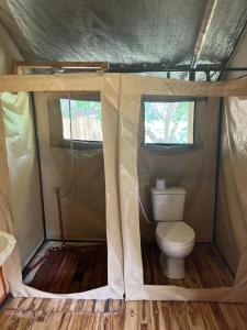 a toilet in a tent in a wooden floor at Keremasi Camp Lake Natron in Mtowabaga
