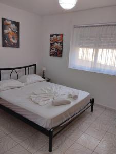 Un dormitorio con una cama con toallas. en Seaside Break Apartment, en Sarandë