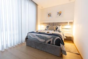 ein Schlafzimmer mit einem Bett und einem großen Fenster in der Unterkunft Coruja’s House AL OPO in Porto