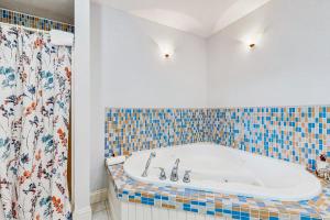 a bathroom with a tub with a tiled wall at The Betty in Jackson +19 photos