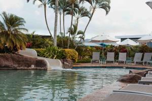 a pool at a resort with a water slide at Kauai Kiahuna Plantation #402 by Coldwell Banker Island Vacations in Koloa