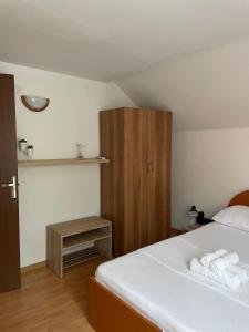 a bedroom with a bed and a wooden cabinet at Casa Melania in Eşelniţa