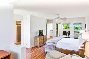 a white bedroom with a bed and a couch at Kauai Manualoha 703 by Coldwell Banker Island Vacations in Kipu