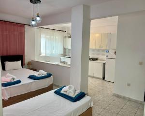 una camera con due letti e una cucina di PELEKAN rooms and apartments athina 11 a Pefkohori