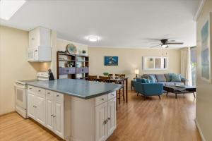eine offene Küche und ein Wohnzimmer mit einem Sofa in der Unterkunft Kauhale Makai 203 by Coldwell Banker Island Vacations in Kihei