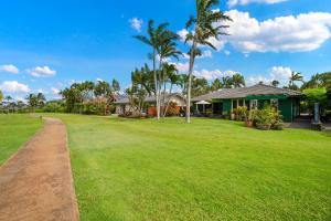 Un gran patio con casas y palmeras. en Kauai The Palms at Poipu Kai 1752 by Coldwell Banker Island Vacations, en Koloa
