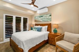 un dormitorio con una cama y una silla en Kauai The Palms at Poipu Kai 1752 by Coldwell Banker Island Vacations, en Koloa 60 fotos más