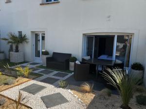 a patio with a table and chairs and plants at Villa Riva-Mela in Ouistreham