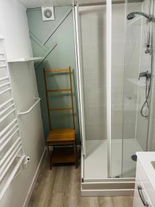 a shower with a wooden chair in a bathroom at Villa Riva-Mela in Ouistreham +10 photos