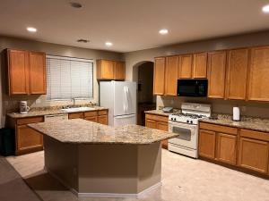 a large kitchen with wooden cabinets and white appliances at Goodyear 2 Story Room 3 in Goodyear