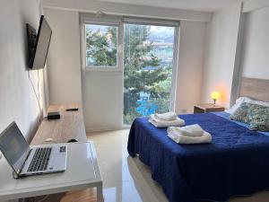 - une chambre avec un lit et un ordinateur portable sur une table dans l'établissement Gray Fox Apartments - Martial, à Ushuaia