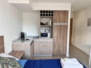 - une petite cuisine avec un lit et un four micro-ondes dans l'établissement Gray Fox Apartments - Martial, à Ushuaia