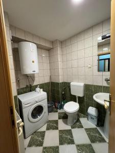 a bathroom with a washing machine and a toilet at VD Apartment 2 ,only 5 min from main Bus Station in Skopje