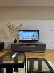 a living room with a flat screen tv on a entertainment center at VD Apartment 2 ,only 5 min from main Bus Station in Skopje