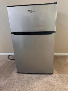 a stainless steel refrigerator in a corner of a room at Goodyear 2 Story Room 4 in Goodyear