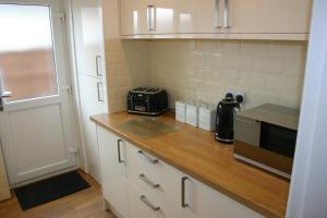 a kitchen with a counter with a toaster and a microwave at Swn y Mor (Sound of the Sea) in Prestatyn