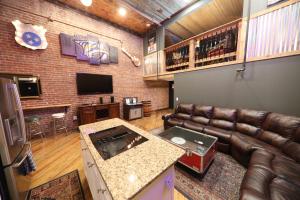 a living room with a leather couch and a television at The Law Suites in Nashville
