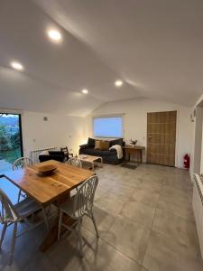 a living room with a table and a couch at Los Coirones 3 - Cabaña con jardin in Dina Huapi +8 photos